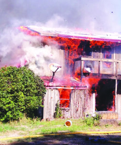 Flames erupt from the second floor of an empty house near Pompeys Pillar Saturday. Worden firefighters burned the house as a training exercise. Click on image to enlarge. (Carrie Killen photo)