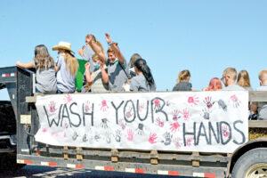 The Huntley Compass All Stars 4H Club ride their float in theHomesteader Days parade with a big sign on the side that saysWash your hands. (Jonathan McNiven Photo)